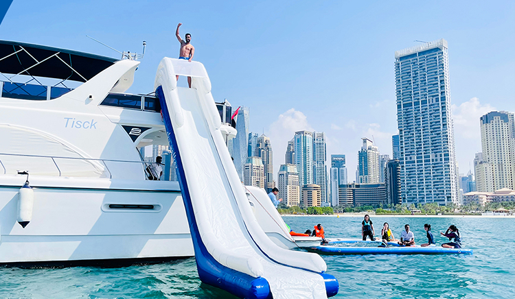 Tourists play ride & slide on a yacht rental in Dubai